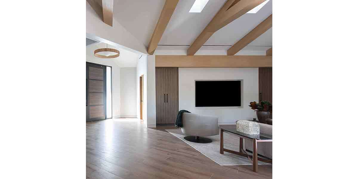 Contemporary living room with wood beams, neutral tones, and sleek furniture.