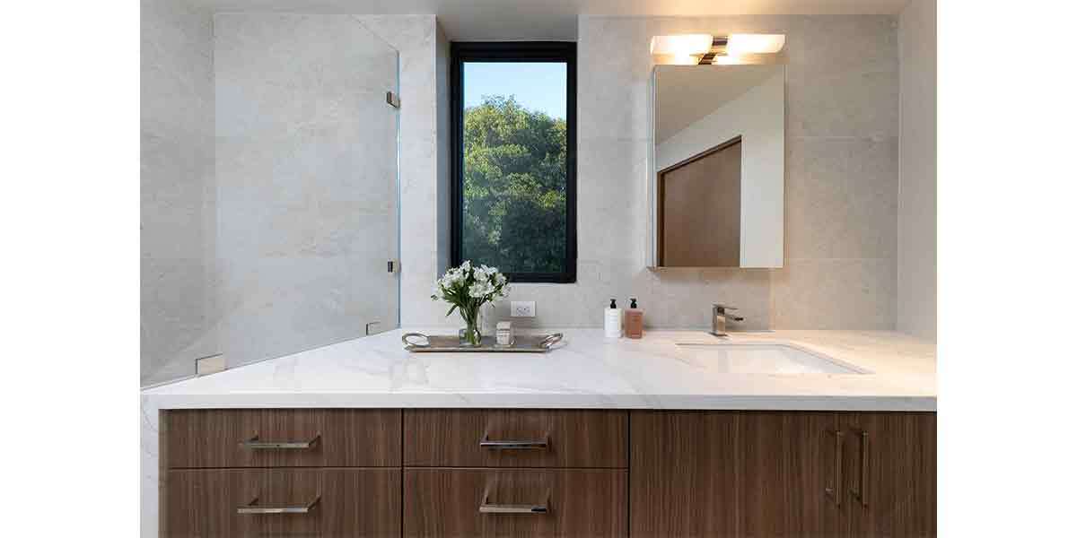 Bathroom vanity with sleek design and natural light from window.
