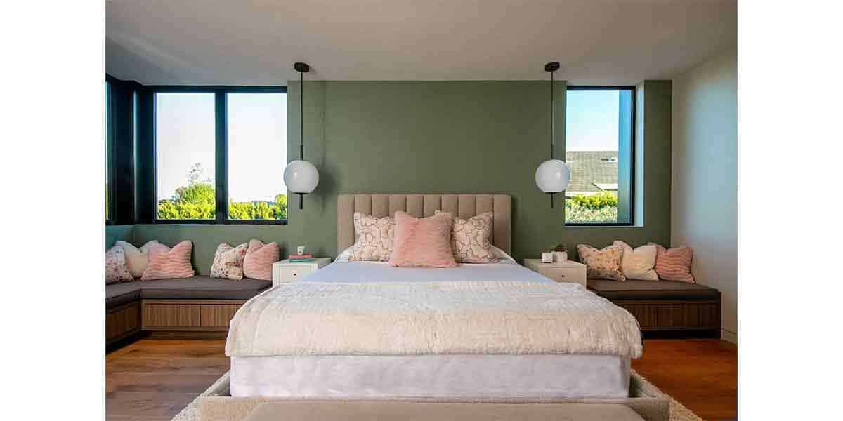 Elegant bedroom featuring a plush bed, built-in window seats, and contemporary lighting for stylish.