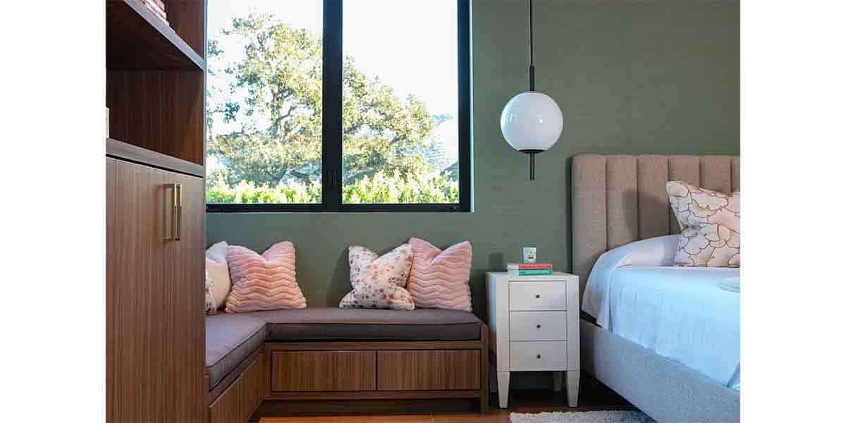 Modern bedroom with cozy seating area and large window for natural light.