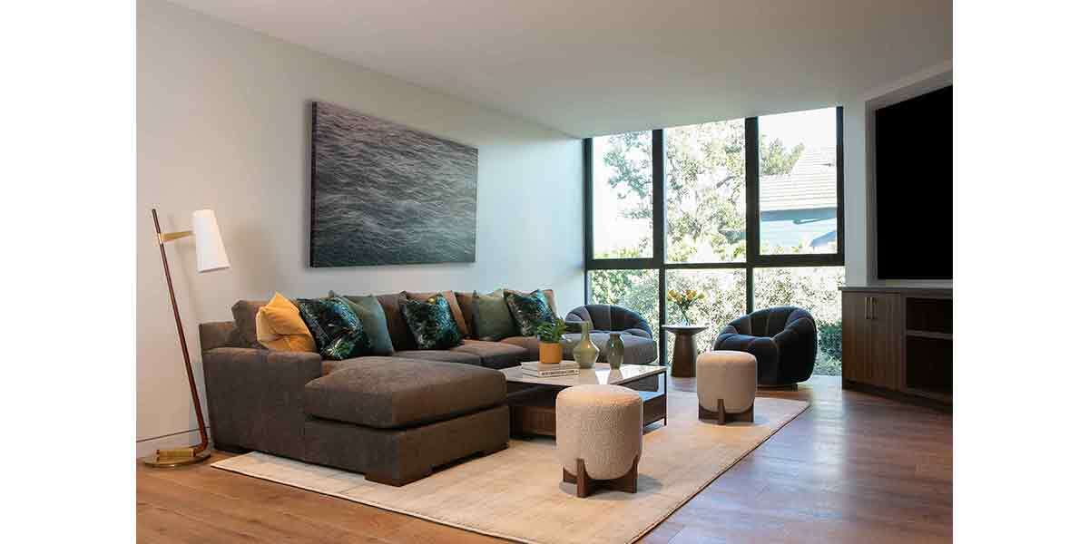 Spacious living room featuring a large sectional sofa, modern decor, and ample natural light from ex.