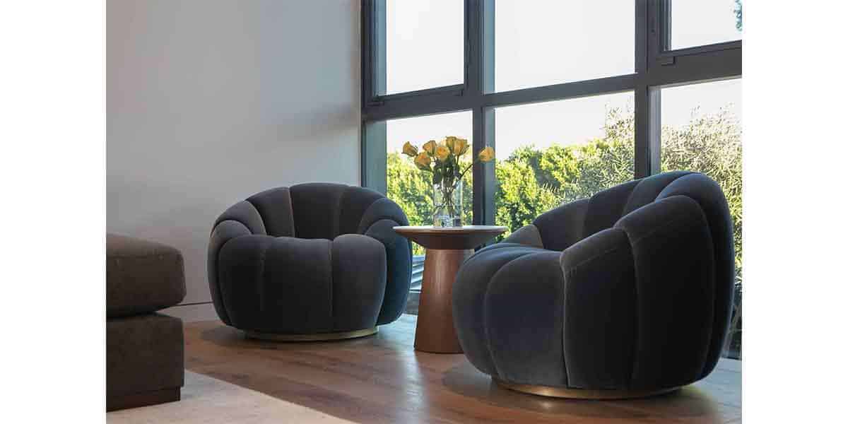 Stylish modern lounge chairs with a small wooden table near large windows.