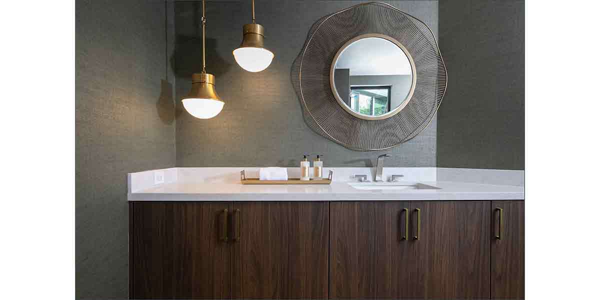 Modern bathroom vanity with dark wood cabinets and a decorative round mirror.