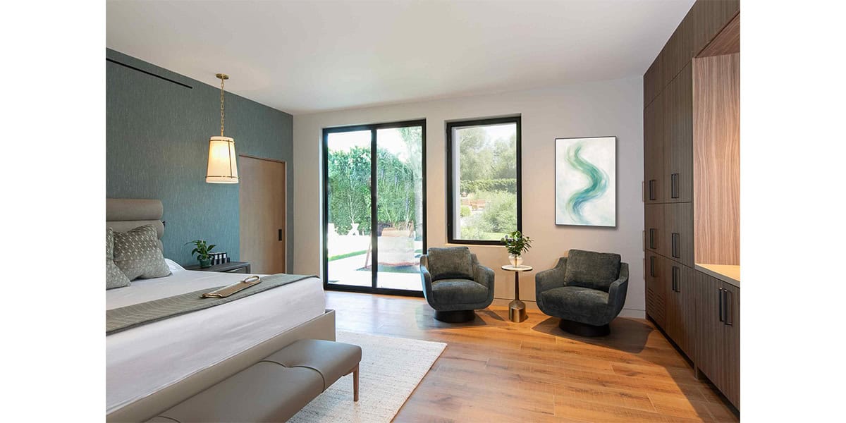 Bright modern bedroom with large windows, cozy seating, and wooden accents.