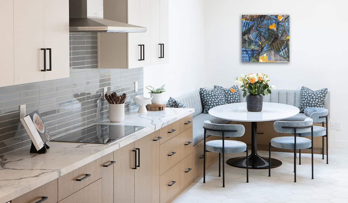 Bright modern kitchen with dining nook and artwork, stylish and functional design.