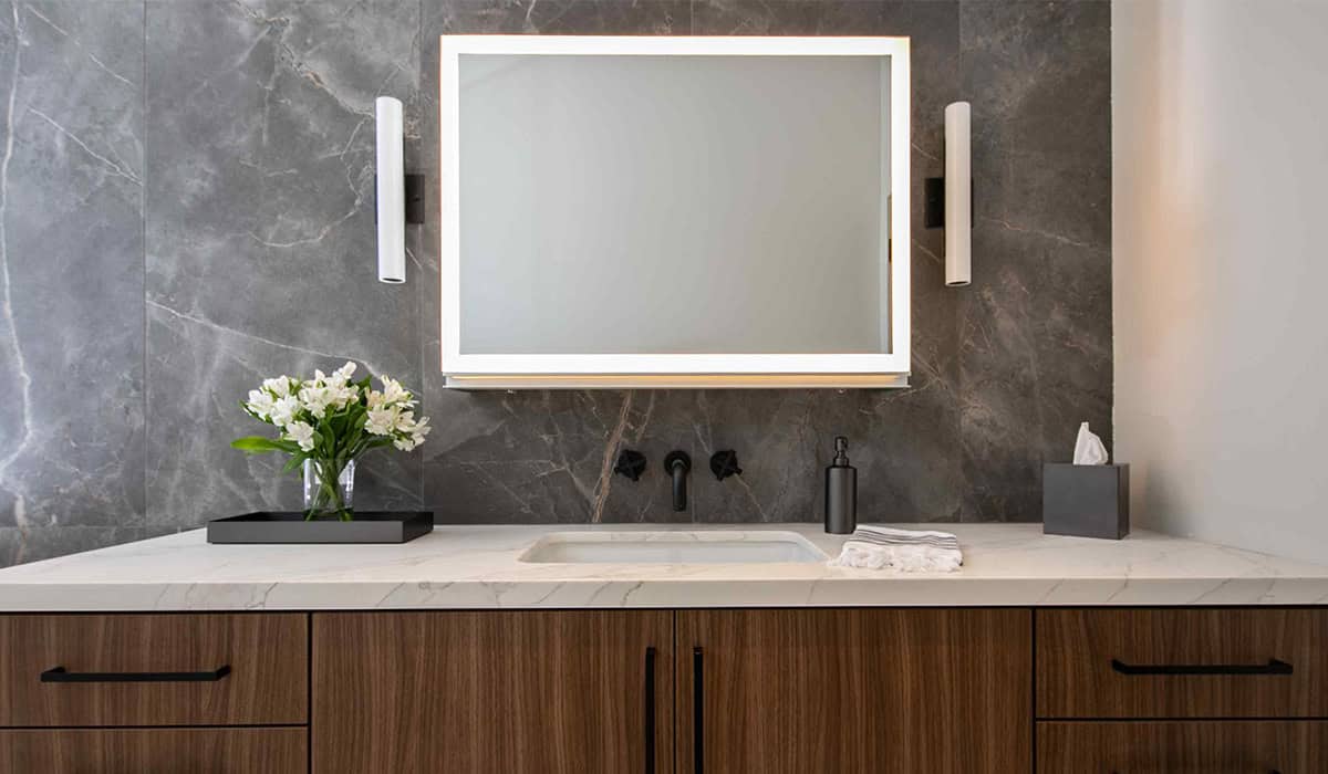 Elegant bathroom vanity with sleek mirror and contemporary lighting fixtures.